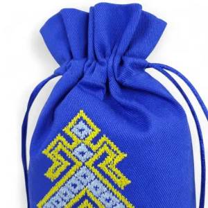 Шнурки синього мішечка оберега та деталь вишивки макош
