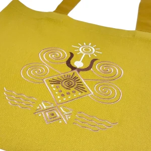 Крупний план вишивки трипільського символу «Велика Богиня» на гірчичному шопері